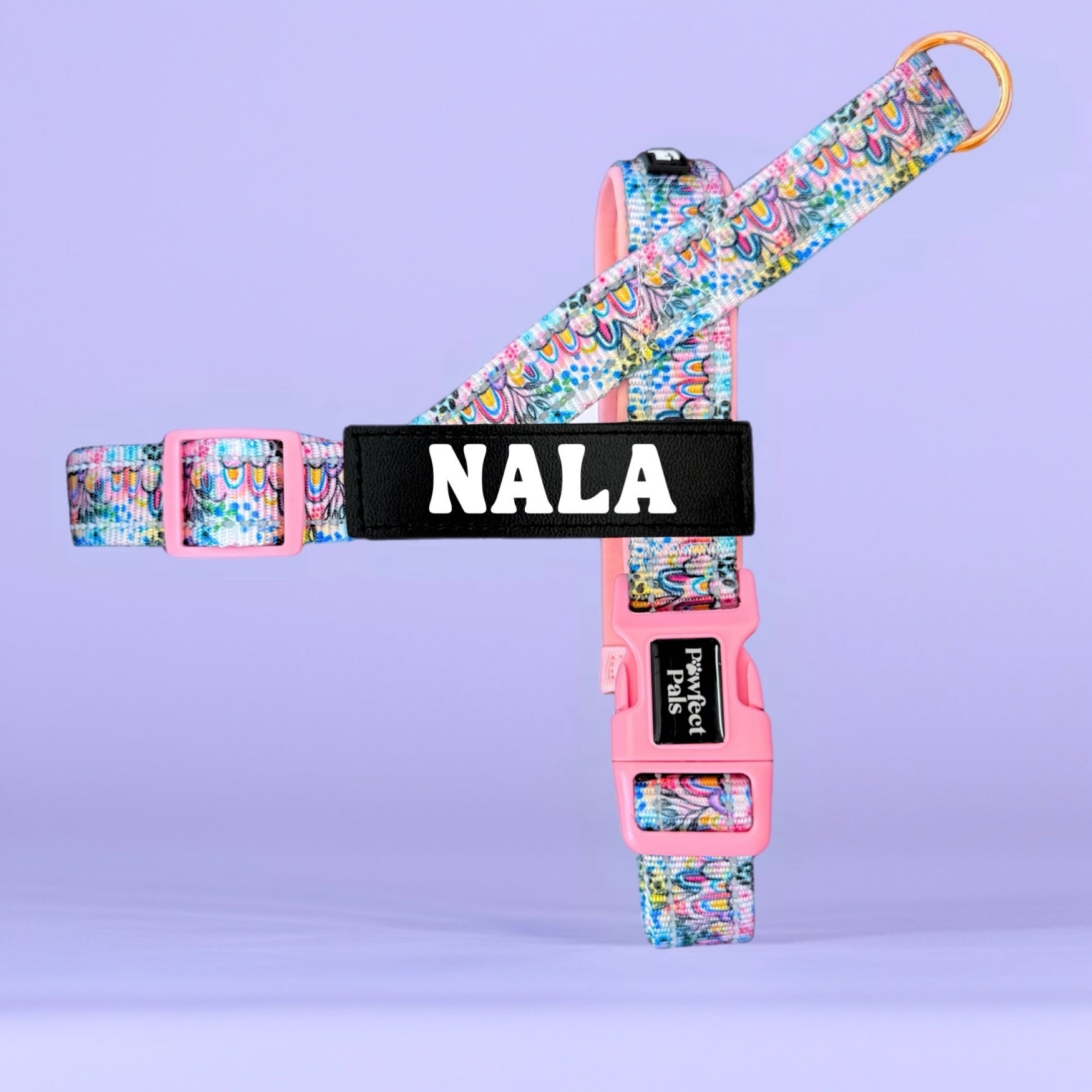 Floral-patterned dog harness with 'NALA' branding on a purple background