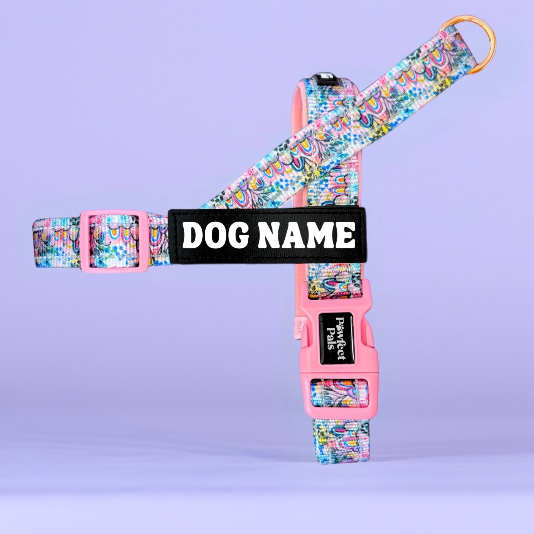 Colorful dog harness with 'DOG NAME' label on a purple background
