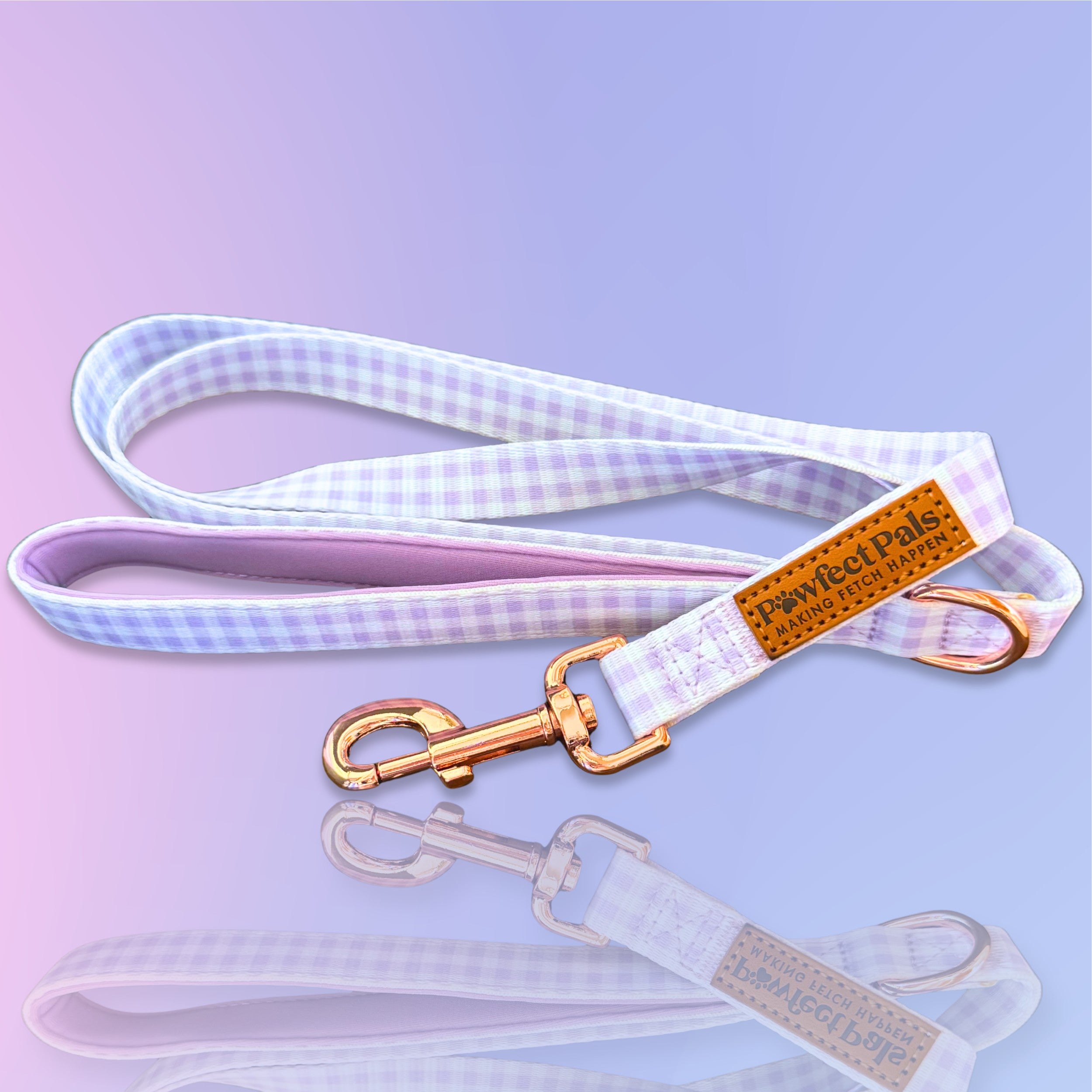 Dog leash with checkered pattern and gold hardware on a light purple background