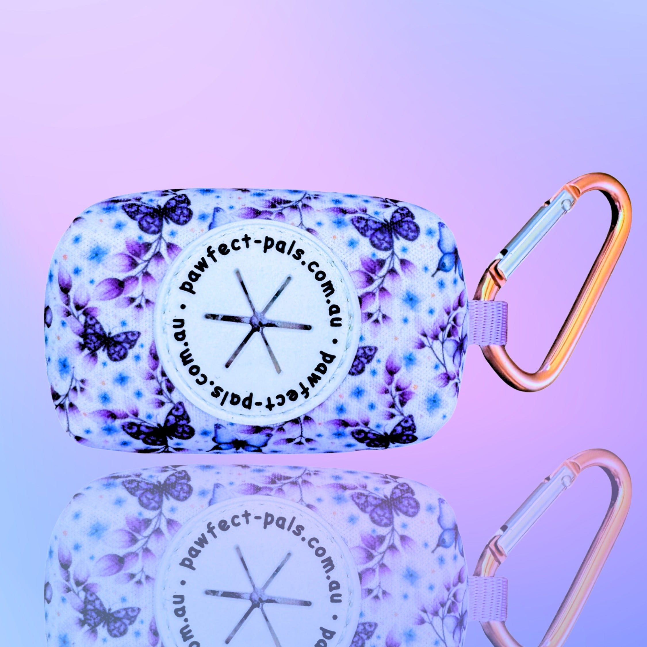 Floral-patterned product case with carabiner on a reflective surface against a gradient purple background