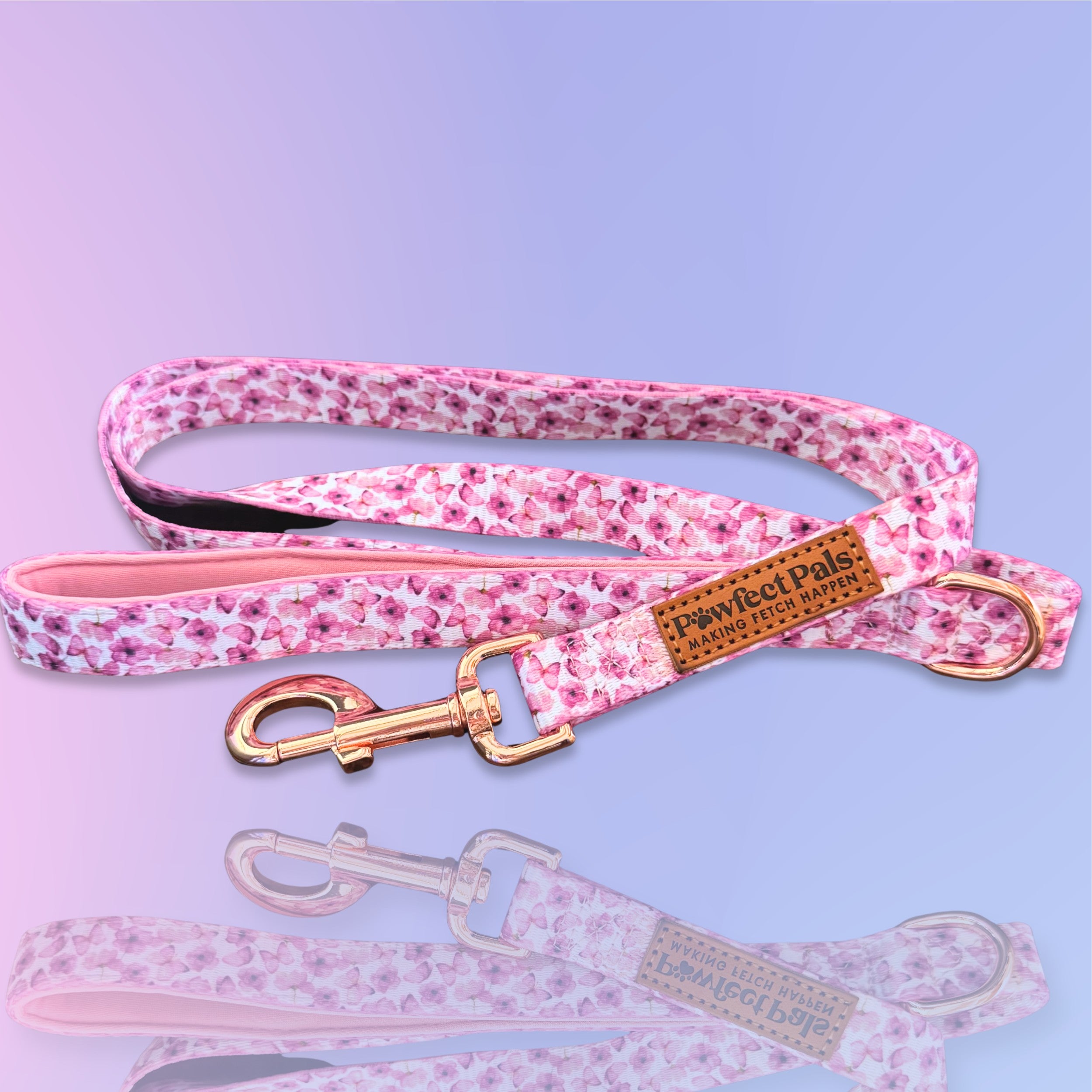 Pink floral dog leash with gold clip on a purple background
